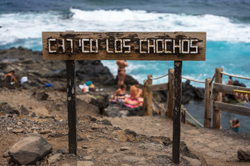 Weathered wooden sign for natural lava pools Charco Los Chochos in Los Silos, Tenerife, Canary Islands, Spain