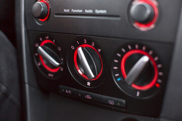 Fototapeta premium Close-up view of car climate control knobs with red accents, showcasing modern automotive design and functionality in a sleek dashboard environment