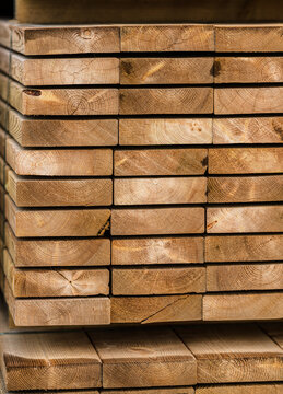 Stacked wooden lumber planks with visible growth rings.