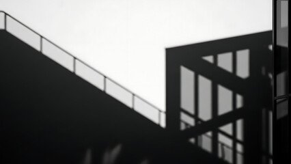 Obraz premium Monochrome view of a modern building's facade with striking geometric shadows and clean architectural lines
