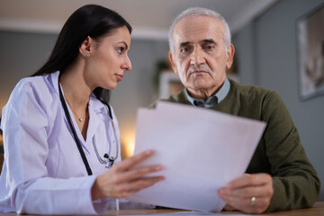Fototapeta premium Doctor discussing medical test results with senior patient