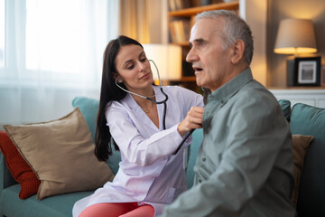 Obraz premium Doctor doing medical checkup on senior man at home