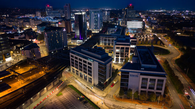 Aerial drone photo of Cardiff city centre at night, featuring Central Square, BBC studios, bus and railway stations.