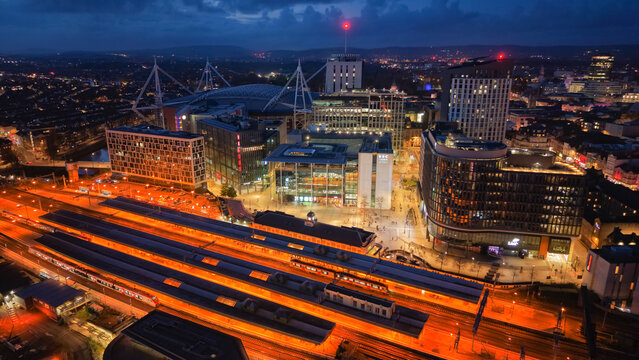 Aerial drone photo of Cardiff city centre at night, featuring Central Square, BBC studios, bus and railway stations.
