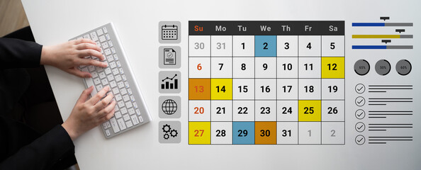 A modern workspace featuring hands typing on a keyboard next to a colorful calendar. This setup showcases efficient time management tools ideal for productivity-focused environments. Gantry
