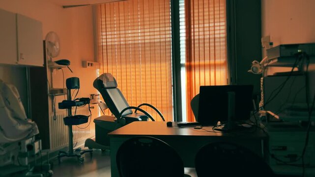 Modern gynecology examination room with medical chair and equipment