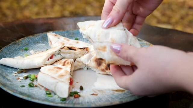 Traditional Mexican food, tex mex cuisine. Hands taking cooked quesadilla from wooden tray and dipping into sauce, tacos served with meat and vegetables, tomato soup with cilantro.