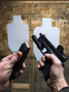 BALTICS - JANUARY 13, 2026: Tactical target shooting practice with a Glock 19 pistol featuring a red dot sight, flashlight, and threaded barrel.