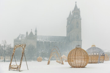 Winter scene Domplatz Magdeburg Dom cathedral silhouette snow fog background festive Lichterwelt light installation. Snow cover square cold weather holiday decoration historic architecture cityscape