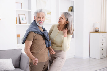 Lovely senior couple dancing together at home