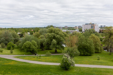 View of urban park with walking paths and city buildings in Ottawa, Canada in spring