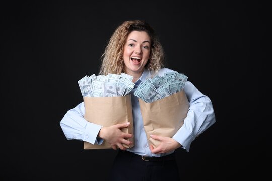 Happy businesswoman with bags full of money on black background - Powered by Adobe