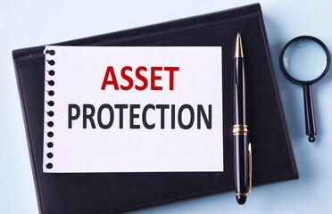 ASSET PROTECTION - words in notepad on black notepad, magnifying glass and pen background