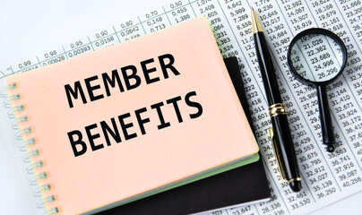 MEMBER BENEFITS - words on a yellow notebook on a background of digital tables, a magnifying glass and a pen