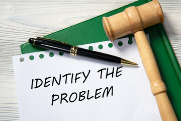 IDENTIFY THE PROBLEM - words in white paper against the background of a green folder and a judge's gavel