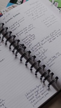Open spiral bound notebook showing handwritten notes on lined paper, reflecting concepts of education, productivity, organization, and personal development