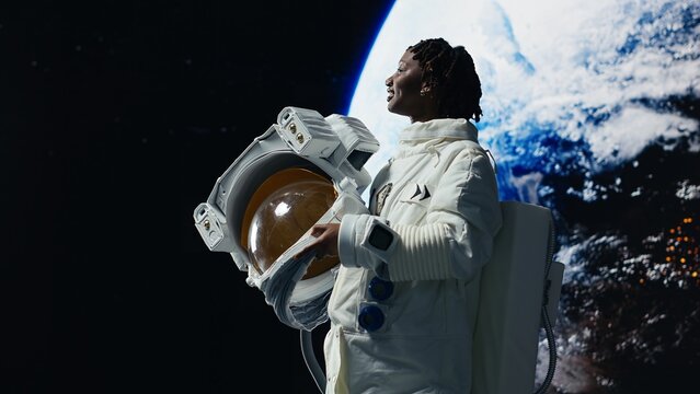 Orbital station crew member moved by beauty of Earth in space, excited to go home. Joyous African american woman feeling emotions when looking back at home planet, rotating 360 degrees, camera B