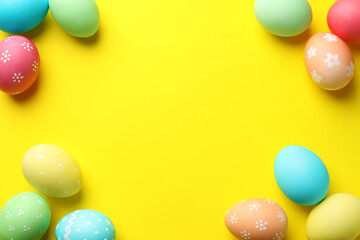 Frame made of many painted Easter eggs on yellow background, flat lay. Space for text
