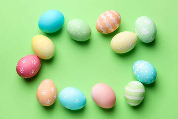 Beautiful decorated Easter eggs on green background, flat lay. Space for text