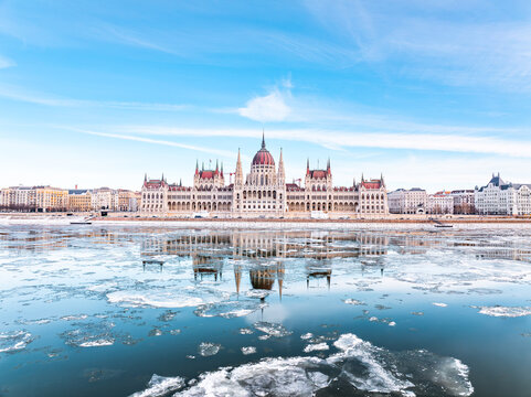 The Parliament of Hungary in Icy Winter time and it's mirrored picture on the freezing Danube, Budapest Hungary