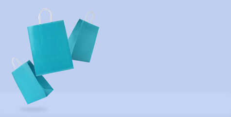 Shopping bags in air on pale blue background. Banner design with space for text. Sale, hot offer,...