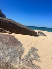 footprints on sand near rocks under blue sky, copyspace, travel, tourism
