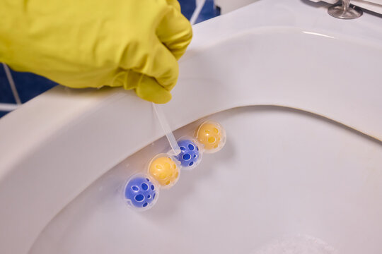 Technician performs detailed cleaning test using effervescent chemicals, Skilled worker meticulously examines toilet sanitation with fizzing cleaning tablets in hand - Powered by Adobe