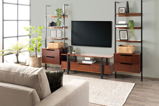 a living room with a large flat screen tv next to it's shelves