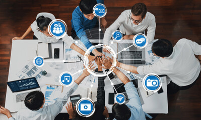 Top view diverse office worker join hand together in office room symbolize business synergy and strong productive teamwork in workplace. Cooperation and unity between business employee. Prudent Amity