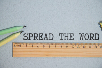 The inscription SPREAD THE WORD on wooden cubes isolated on a light background