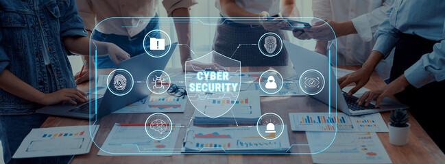 Diverse professionals gather around a table, strategizing cyber security solutions, with high-tech interfaces and data charts visible, showcasing teamwork and innovation. Trope