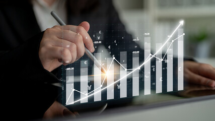 A business professional engages in financial analysis, showcasing growth trends through digital charts and graphs in a contemporary office environment. Impute