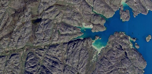 Aerial satellite view of Greenland rocky tundra and melting ice lakes