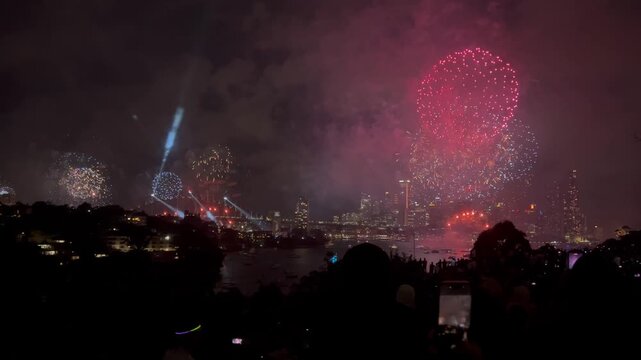 Australian crowd looking at New Years party fireworks display over Sydney Australia. Sydney's NYE is famous for being first to celebrate with massive fireworks on the Harbour Bridge