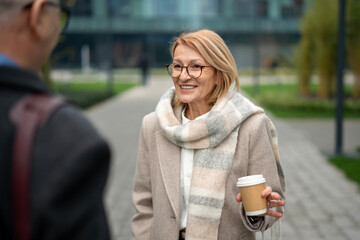 Mature woman smiling while having coffee break conversation