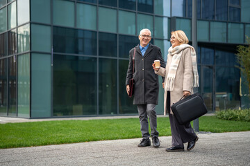 Senior business partners walking and talking outside office