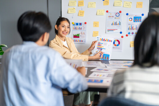Professional asian businesswomen discussing marketing strategy on whiteboard, Female colleagues analyzing data charts and graphs in office meeting, teamwork, planning and financial business concept - Powered by Adobe