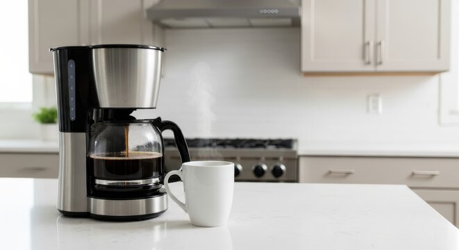 Automatic drip coffee maker brews hot beverage onto bright kitchen counter surface