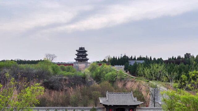 Time-lapse of Qiu Feng Pavilion in Shanxi at cloudy early morning, traditional Chinese architecture nestled among greenery and earthen hills. China