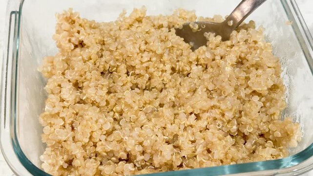 bowl of quinoa , with a serving spoon . 