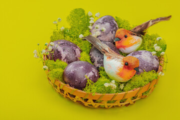 Marble Easter eggs, wooden basket, moss, gypsophila flowers. Festive concept, greeting card