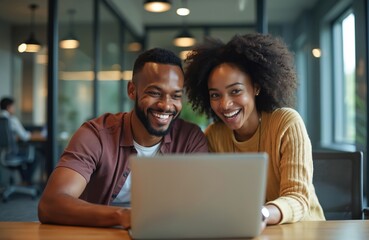 Two smiling coworkers, man and woman, collaborate on laptop in modern office. Diverse team discusses project, sharing ideas, enjoying productive work together.