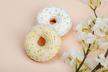 Handmade crocheted donuts with blooming cherry branches. Festive Easter, greeting card
