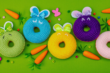 Handmade Easter concept. Crocheted donuts bunnies with traditional decoration. Festive symbols