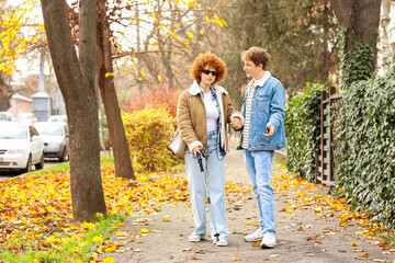 Fototapeta premium Blind young woman with her boyfriend in city on autumn day