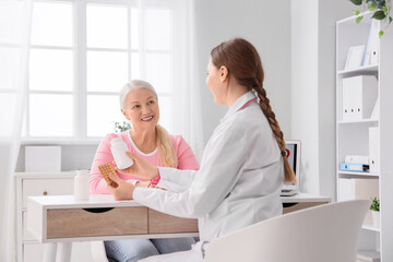 Obraz premium Female gynecologist prescribing pills to patient at table in clinic. Menopause concept