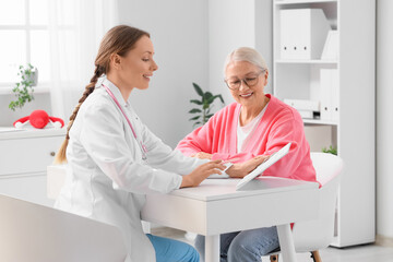Obraz premium Mature woman visiting gynecologist at table in clinic. Menopause concept