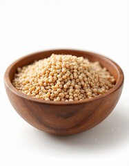 Dry raw buckwheat groats fill wooden bowl, showing small beige grains closeup. Healthy organic ingredient for cooking vegetarian dishes. Staple cereal crop.
