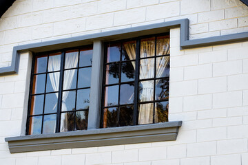 White Brick Cottage Wall with Open Windows and Potted Plants