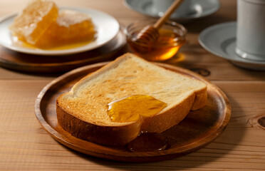 Toasted Bread with Fresh Organic Honey and Honeycomb on a Wooden Plate, Healthy Sweet Breakfast with Copy Space